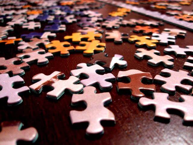 Bunch of puzzle pieces not connected randomly all over a table top